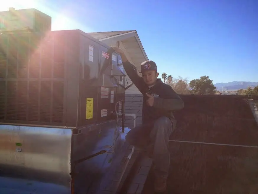 HVAC technician performing Air Duct Cleaning on a rooftop unit in Cupertino